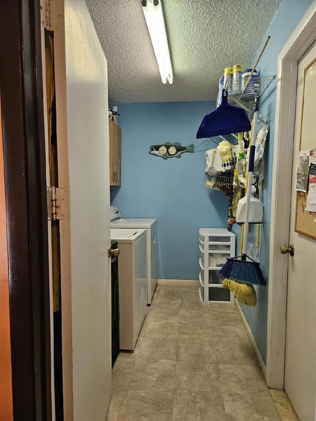 washroom with washer and clothes dryer, cabinets, and a textured ceiling