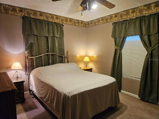 bedroom with ceiling fan, a textured ceiling, and dark colored carpet