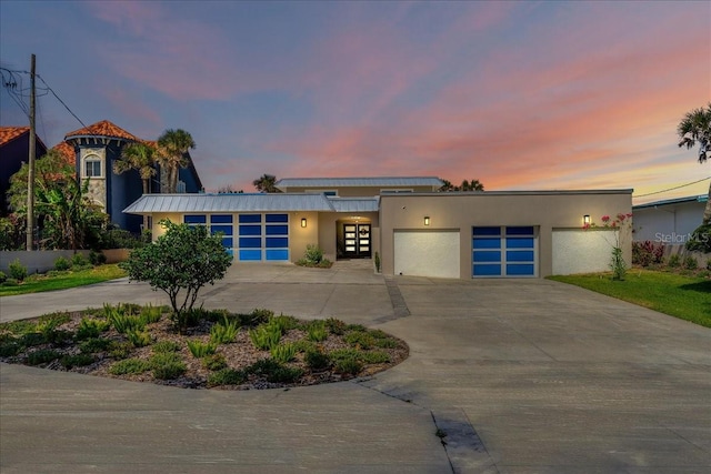 modern home with a garage, driveway, and stucco siding