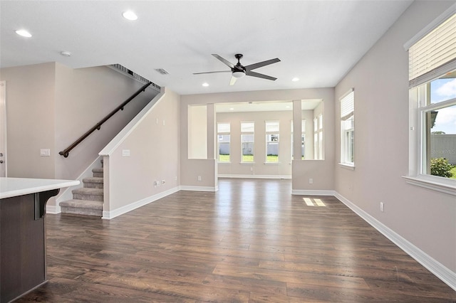 unfurnished living room featuring ceiling fan, plenty of natural light, and dark hardwood / wood-style floors