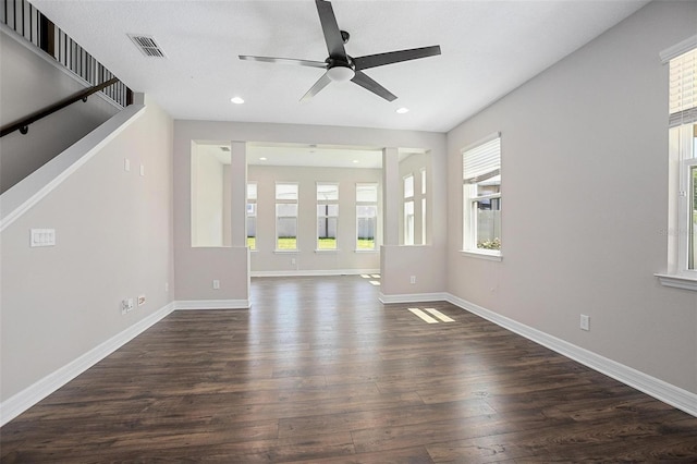 unfurnished living room featuring ceiling fan and dark hardwood / wood-style flooring