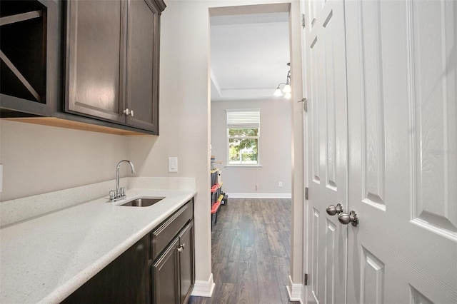 kitchen with dark hardwood / wood-style floors, sink, and dark brown cabinetry