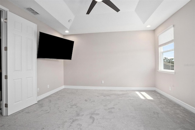 unfurnished room featuring ceiling fan, lofted ceiling, carpet floors, and a raised ceiling