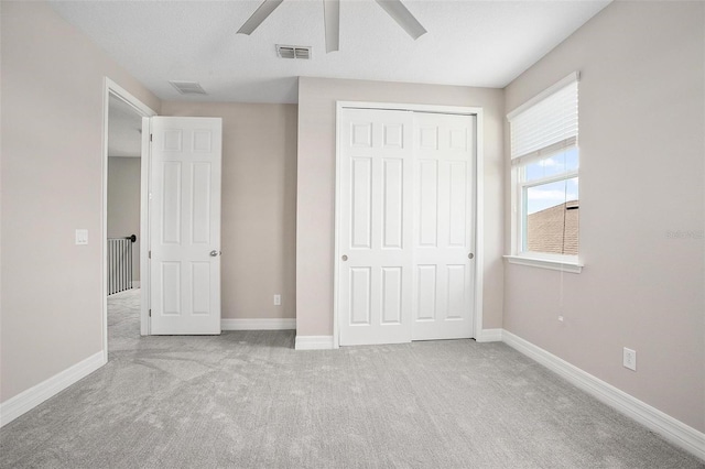 unfurnished bedroom with ceiling fan, a closet, and light colored carpet