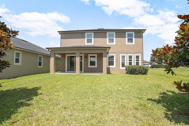 rear view of house featuring a lawn and a patio