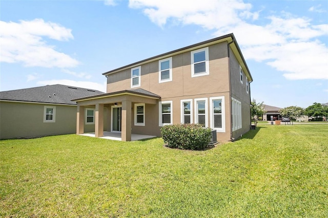 rear view of house with a lawn, central air condition unit, and a patio area