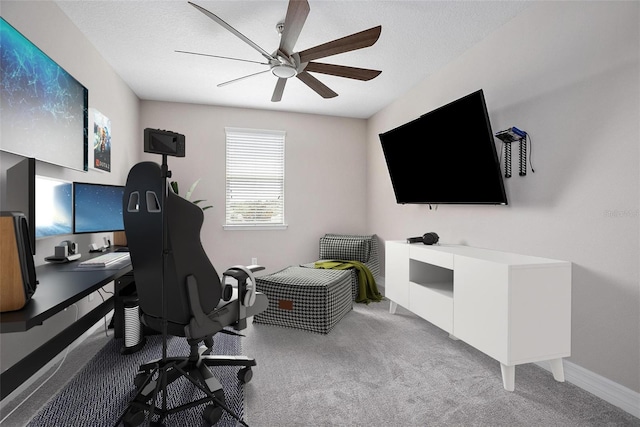 carpeted home office with ceiling fan and a textured ceiling