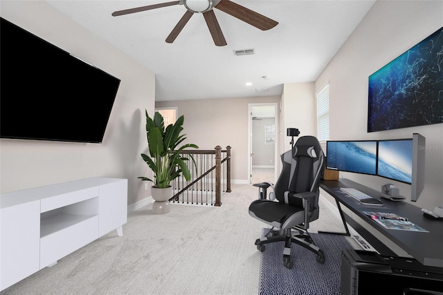 office space featuring light carpet and ceiling fan