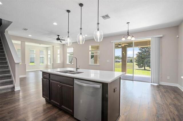 kitchen featuring dishwasher, sink, hanging light fixtures, an island with sink, and ceiling fan with notable chandelier