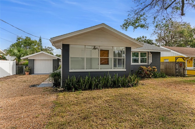 view of front of home with a garage, an outbuilding, and a front yard