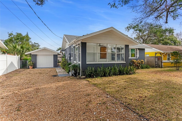 view of front of home with a garage, a front lawn, and an outdoor structure