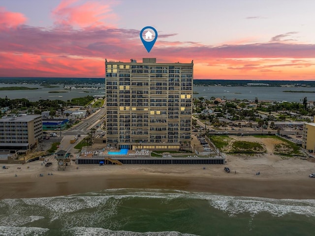 aerial view at dusk featuring a water view