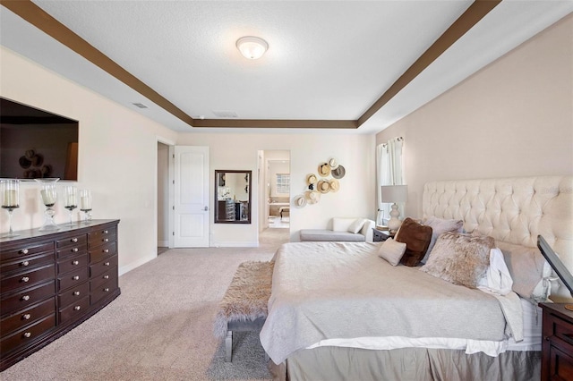 bedroom featuring light colored carpet, a textured ceiling, and a tray ceiling