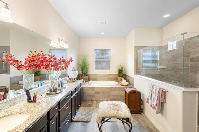 bathroom featuring vanity, shower with separate bathtub, and hardwood / wood-style flooring