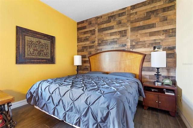 bedroom featuring dark hardwood / wood-style floors and wooden walls