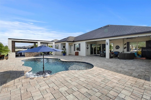 view of swimming pool featuring outdoor lounge area, ceiling fan, and a patio