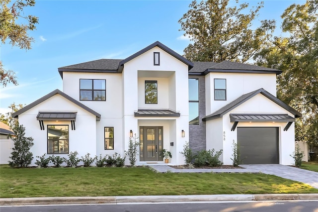 modern inspired farmhouse featuring a front lawn and a garage