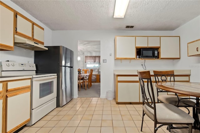 kitchen featuring cream cabinetry, light carpet, white range with electric cooktop, and a textured ceiling