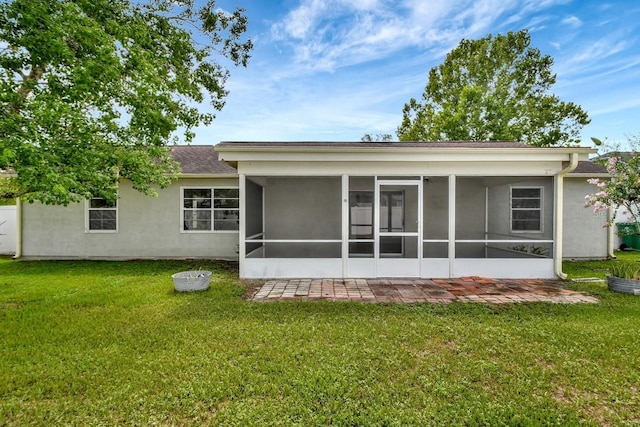 rear view of house with a sunroom and a yard