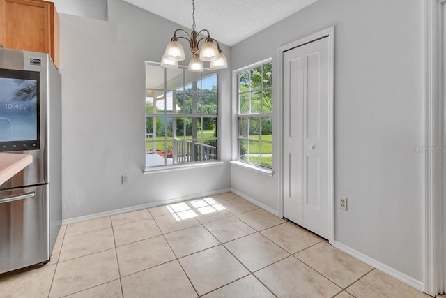 unfurnished dining area with plenty of natural light, light tile patterned floors, and a textured ceiling