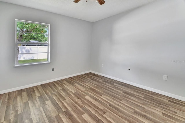 empty room with hardwood / wood-style floors, ceiling fan, and a textured ceiling