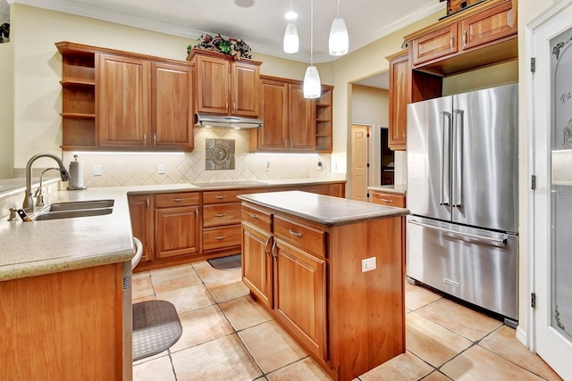 kitchen with a center island, ornamental molding, high end fridge, sink, and tasteful backsplash