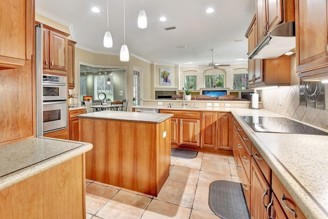 kitchen featuring a kitchen island, backsplash, black electric cooktop, ornamental molding, and stainless steel double oven