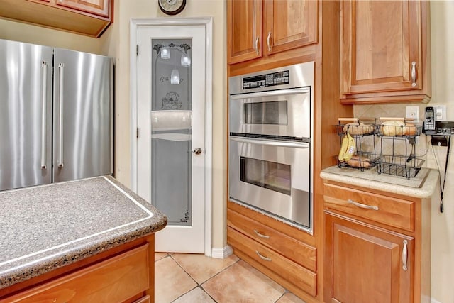 kitchen featuring appliances with stainless steel finishes and light tile floors