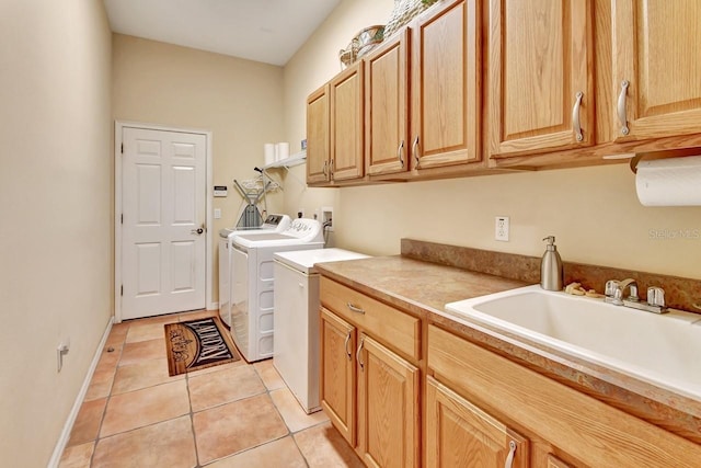 clothes washing area with cabinets, washer hookup, washing machine and dryer, sink, and light tile floors