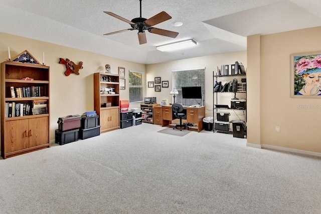 carpeted office space featuring ceiling fan and a textured ceiling