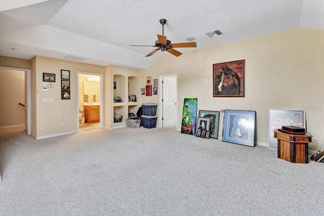 living room with carpet flooring, ceiling fan, a textured ceiling, and lofted ceiling