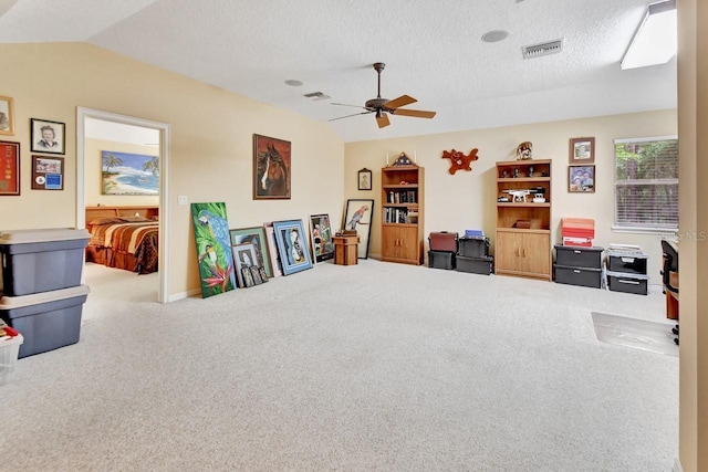 interior space with a textured ceiling, ceiling fan, vaulted ceiling, and carpet floors