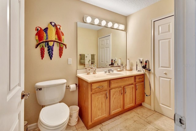 bathroom with tile floors, a textured ceiling, vanity, and toilet