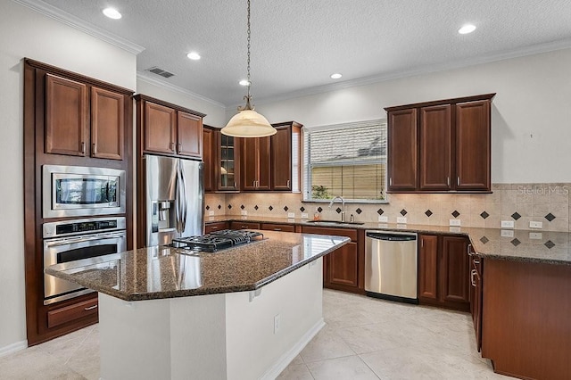 kitchen featuring a center island, dark stone countertops, sink, and appliances with stainless steel finishes