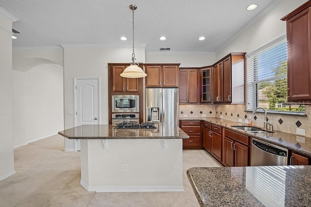 kitchen featuring a center island, sink, appliances with stainless steel finishes, and dark stone counters