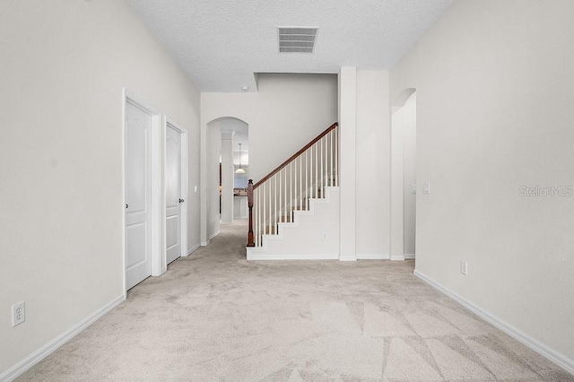 interior space with light carpet and a textured ceiling