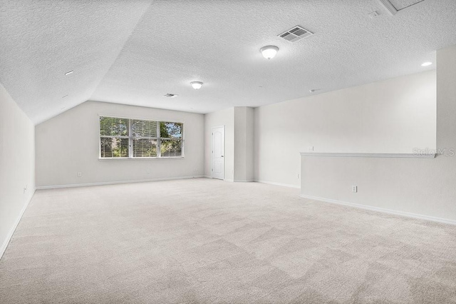 interior space with a textured ceiling, light colored carpet, and lofted ceiling