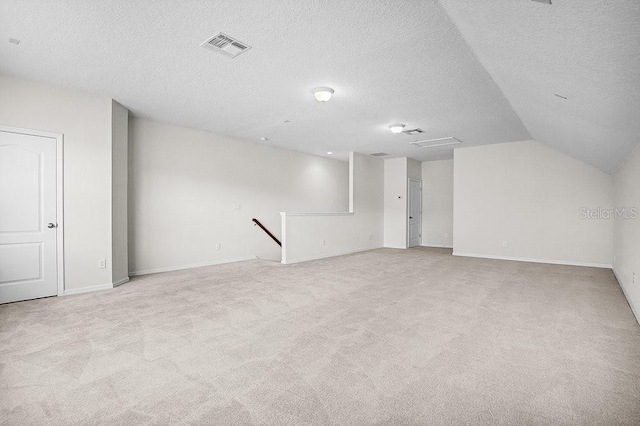 interior space with a textured ceiling and vaulted ceiling