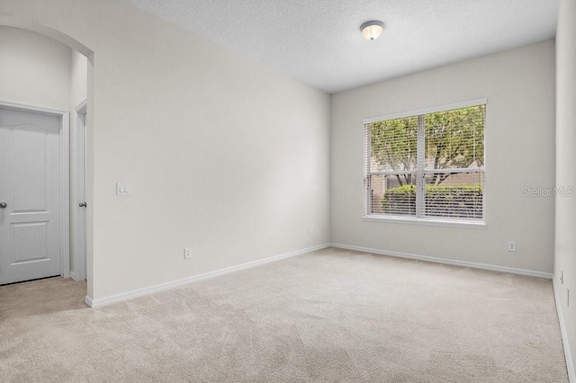 carpeted spare room featuring a textured ceiling