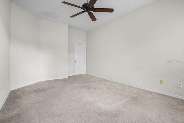 carpeted spare room with ceiling fan and a high ceiling