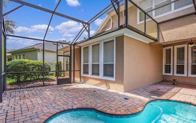 view of pool featuring glass enclosure and a patio