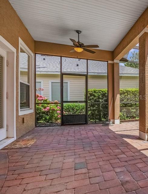 unfurnished sunroom with ceiling fan