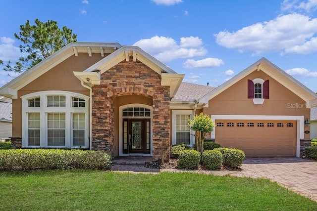 view of front of home featuring stone siding, decorative driveway, an attached garage, and stucco siding