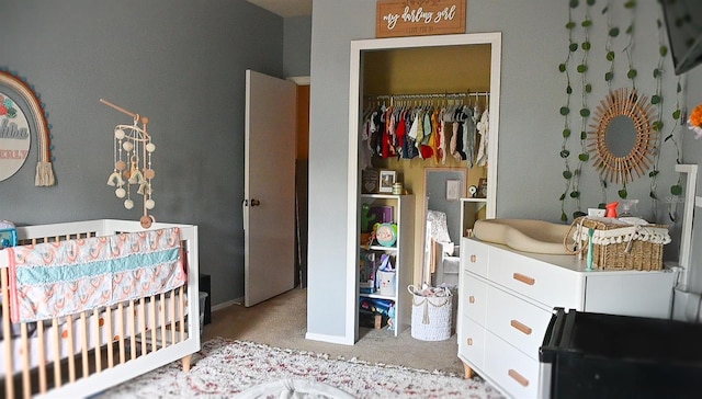 bedroom featuring a closet, light colored carpet, and a nursery area