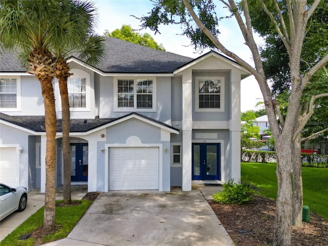 view of front of home with a garage, a front yard, and french doors