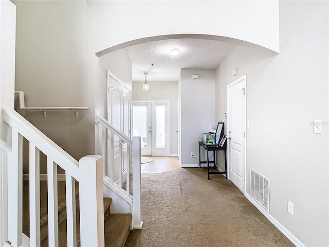 foyer with carpet and french doors