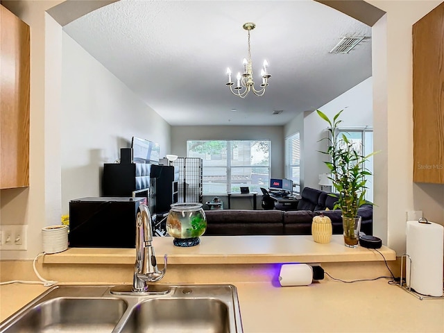 kitchen featuring a notable chandelier, sink, and decorative light fixtures