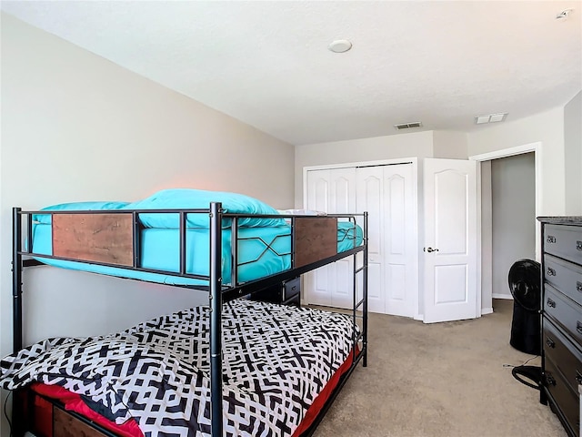 bedroom featuring light colored carpet and a closet