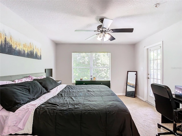 bedroom with ceiling fan, a textured ceiling, light carpet, and multiple windows