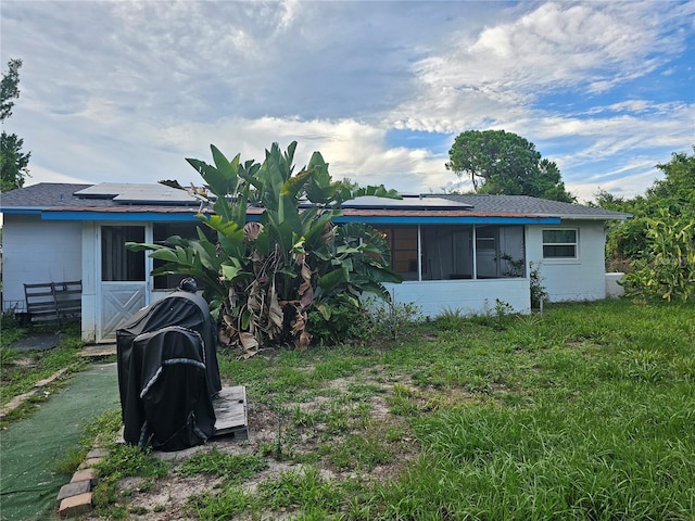 rear view of property featuring solar panels